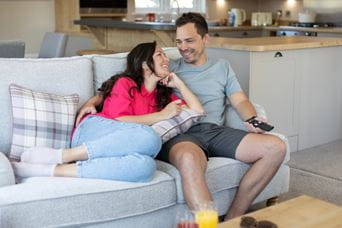 Couple sat cuddling on the sofa