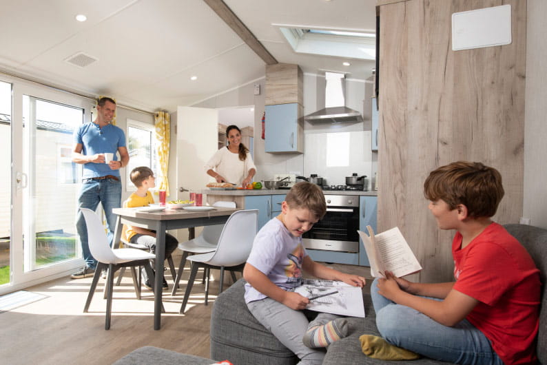 Kids reading books whilst parents cook in the kitchen