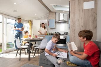 Kids reading books whilst parents cook in the kitchen