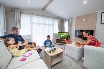 Family playing games in caravan living room