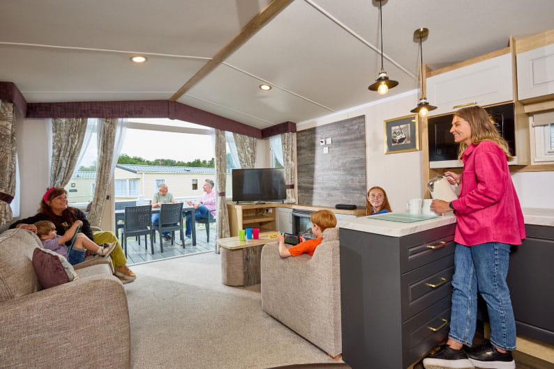 Family sat around in a caravan living room