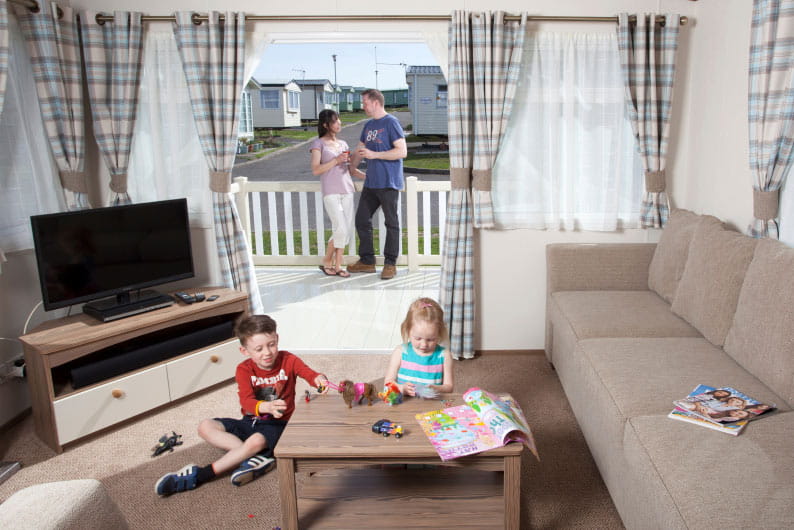 Children playing around the table whilst parents look on from the veranda