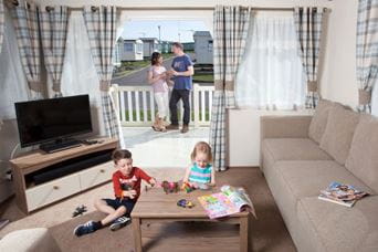 Children playing around the table whilst parents look on from the veranda