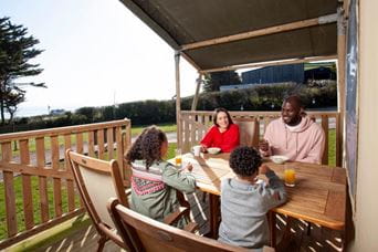 Family sat around table on the veranda