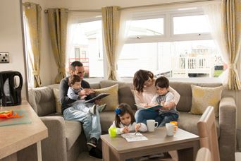 Family sat on sofa cuddling watching TV