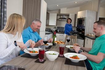 Family sat around dining table eating tea