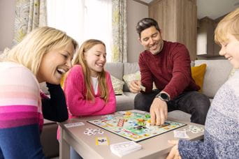 Family gathered around playing monopoly