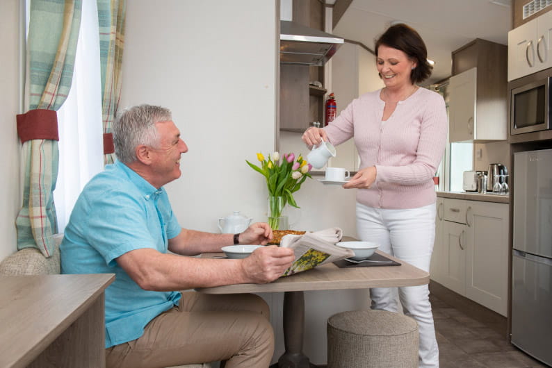 Couple making a cup of tea together smiling