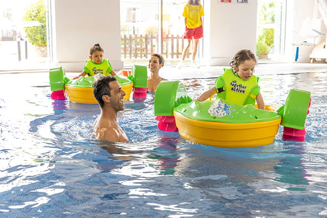 A family on aqua paddlers in the indoor swimming pool at Regent Bay Holiday Park