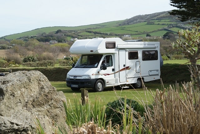A touring caravan parked on the beautiful field at Ruda Holiday Park