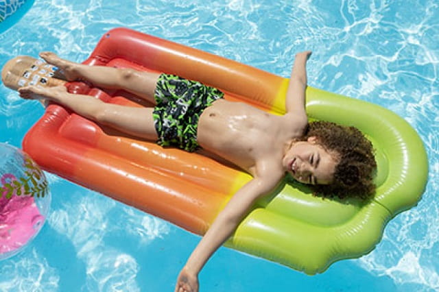 child on a lilo in the outdoor swimming pool