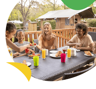 A family enjoying a meal on their glamping tent veranda at Sandford Holiday Park