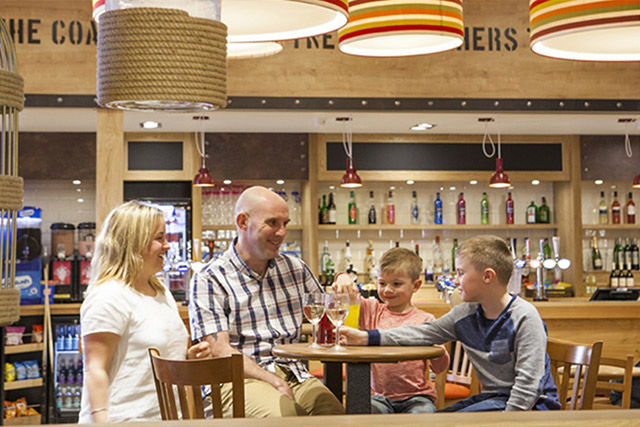 A family enjoying drinks in the bar at Sandy Bay