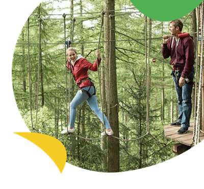 A girl on a high ropes course at Go Ape Newcastle, near Sandy Bay Holiday Park