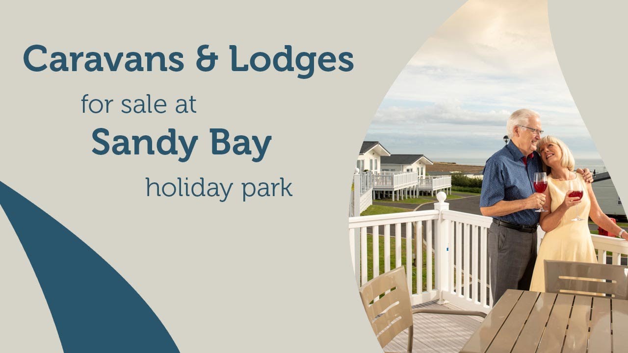 An elderly couple relaxing and enjoying the view from their holiday home veranda at Sandy bay Holiday Park