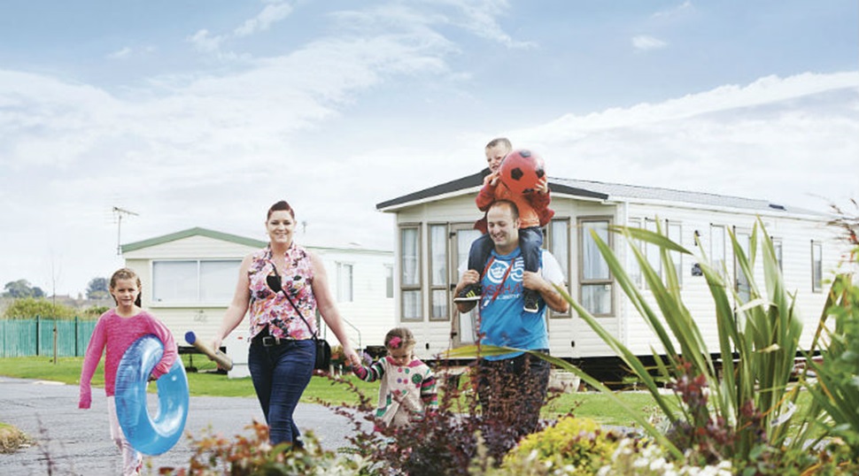 A family walking through Sandylands Holiday Park towards the beach