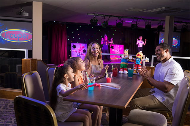 A family watching entertainers on stage at Sandylands Holiday Park