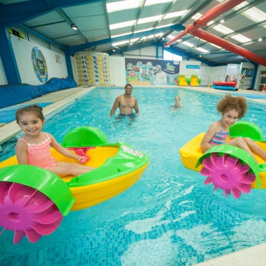 children playing with aqua paddlers in a pool