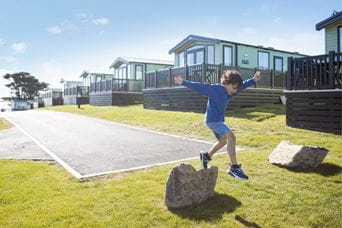 A child playing in a Park Dean Resort in front of the accommodation