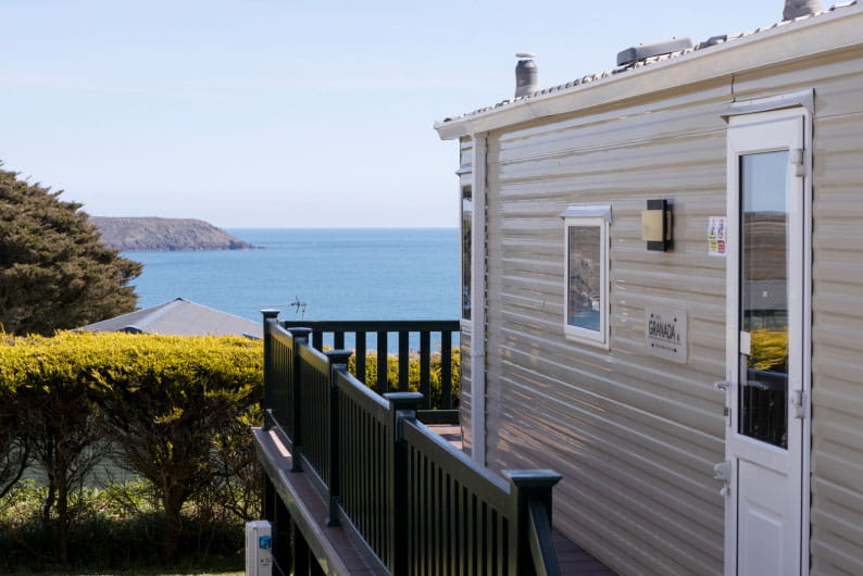 The outside of a Sea Acres caravan with a view of the sea