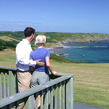 A couple looking out at the sea from their decking