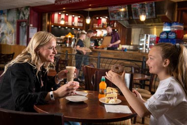 Mother and child eating at a table in a sports cafe