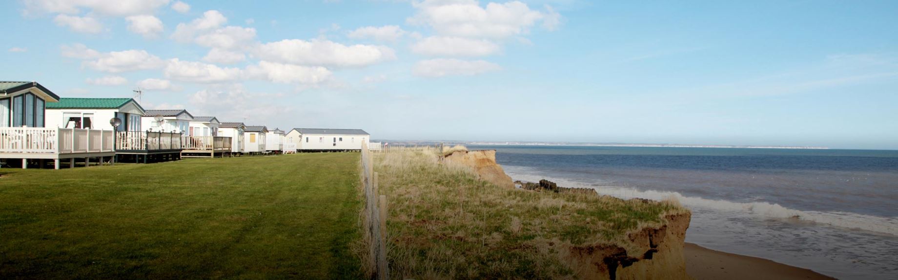 Holiday park caravans on a grassy cliff overlooking the sea