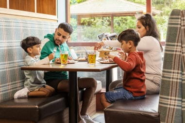 Family enjoying a meal in a restaurant booth