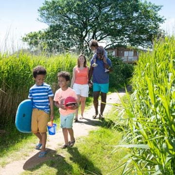 Smiling family walking down a secluded grassy path