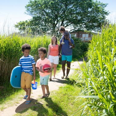 Smiling family walking down a secluded grassy path