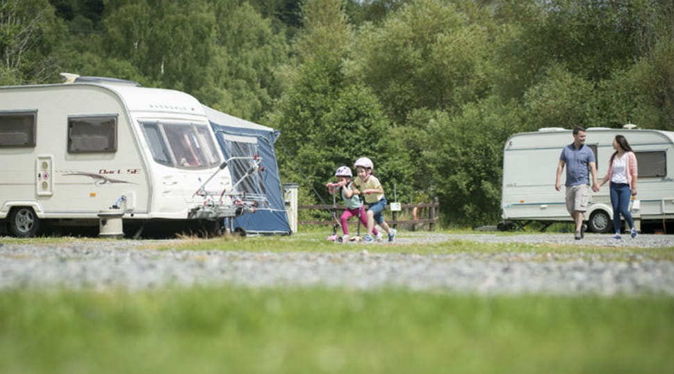 a family walking past touring caravans