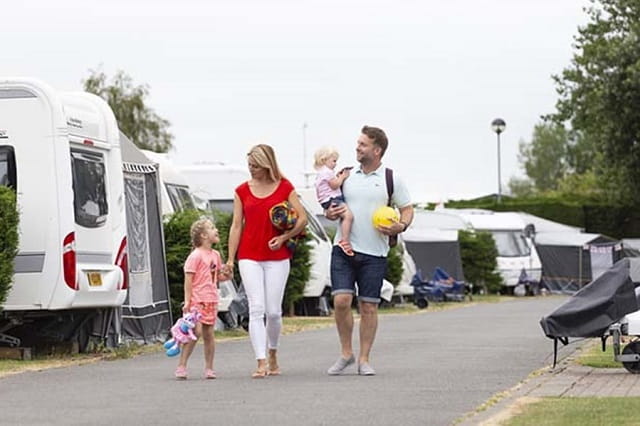 family walking past caravans