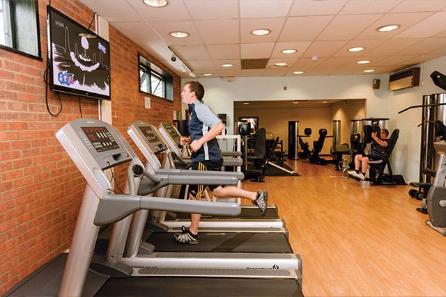 A man on a running machine in the gym