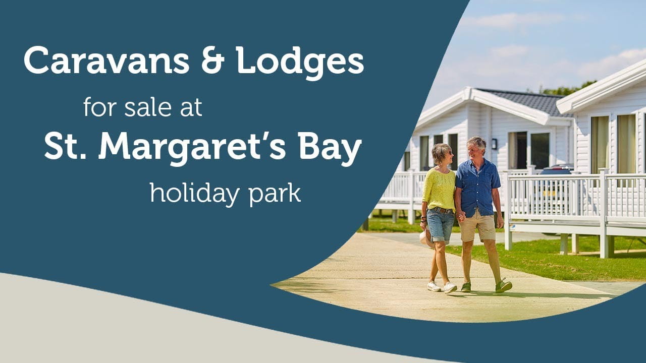 a couple walking past holiday caravans and lodges