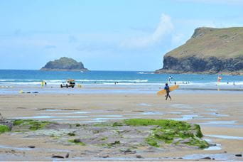 Surfers riding waves on a Cornish beach