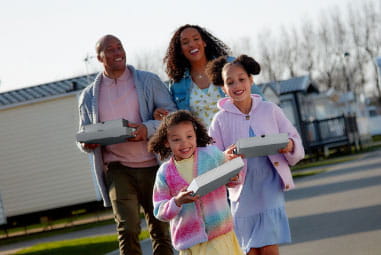 a family carrying takeaway pizza boxes