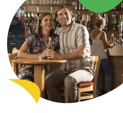 A couple enjoying a drink in the bar at St Minver Holiday Park