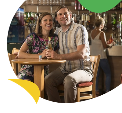 A couple enjoying a drink in the bar at St Minver Holiday Park