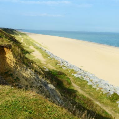 green countryside leading to sandy beaches