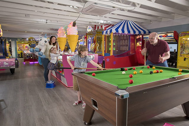 A family playing pool in the amusement arcade