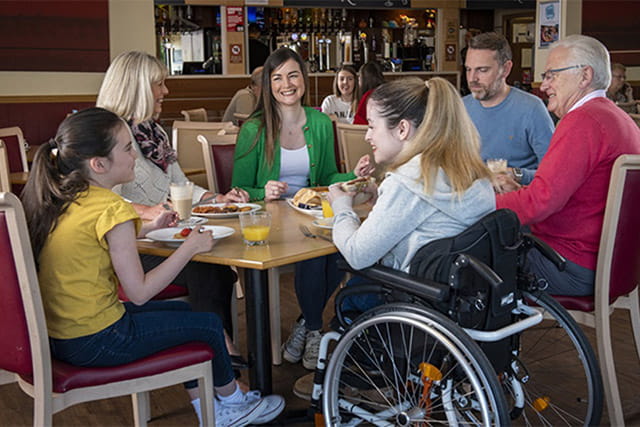 A family enjoying a meal in the restaurant at Sundrum Castle Holiday Park