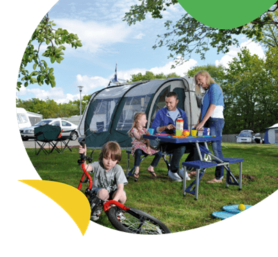 A family relaxing around their tent at Sundrum Castle Holiday Park