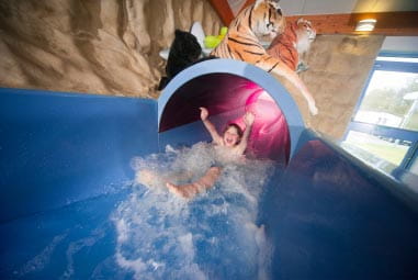 a child sliding down a water slide