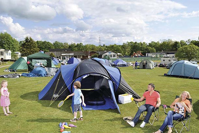 A family relaxing outside their tent at Sundrum Castle Holiday Park
