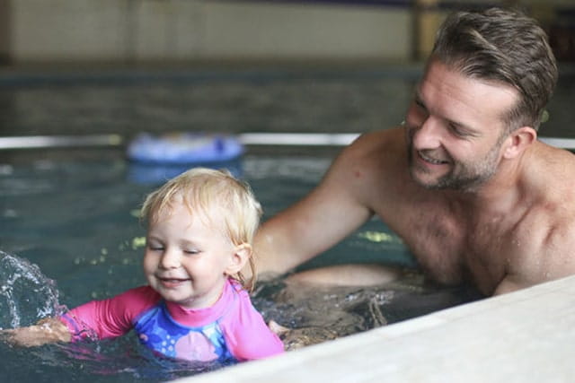 father and daughter in the indoor pool