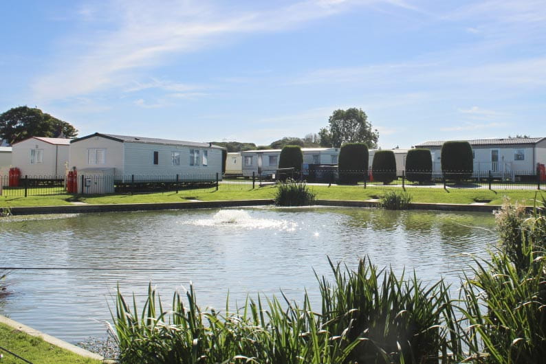 caravan accommodation behind a small lake