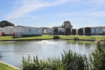 caravan accommodation behind a small lake