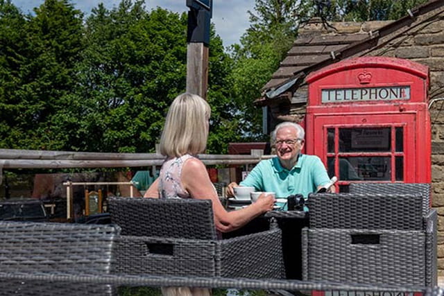 A couple enjoying refreshments on the outdoor patio at Todber Valley
