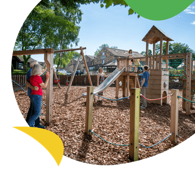 A family playing on the outdoor play area at Todber Valley Holiday Park