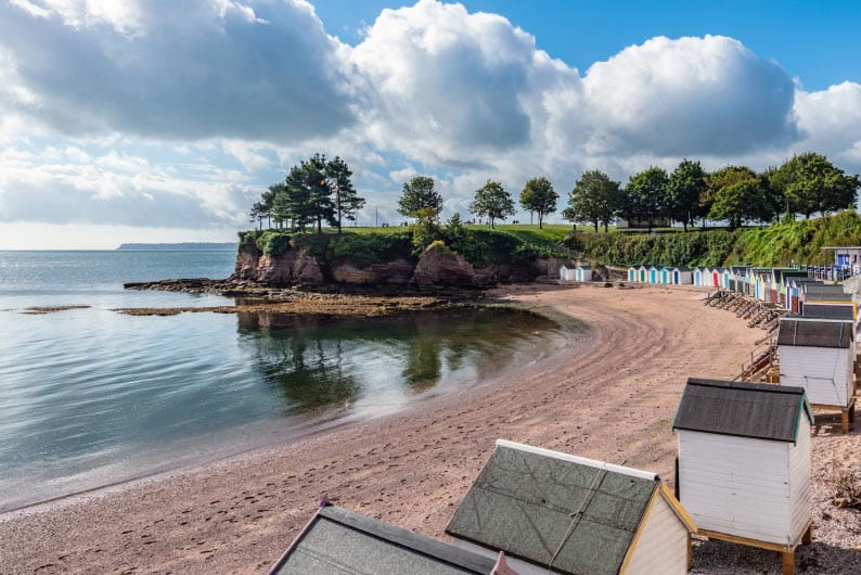 beach huts next to a beach